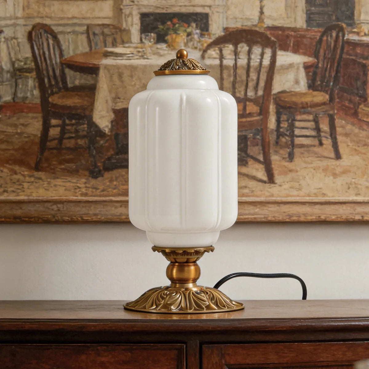 Acanthe, lampe à poser en verre opalin blanc, posée sur un buffet ancien